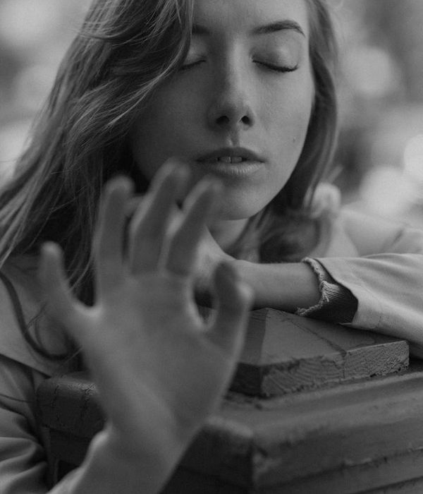 Woman in a calm, flowing cardio pose against a dark background with azure light.